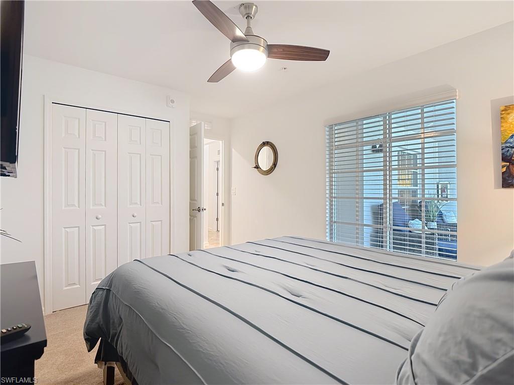 Bedroom featuring light colored carpet, a closet, and ceiling fan
