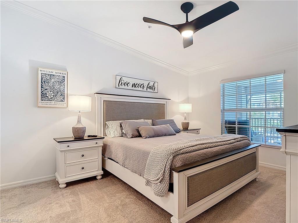 Bedroom with ornamental molding, light colored carpet, and a ceiling fan