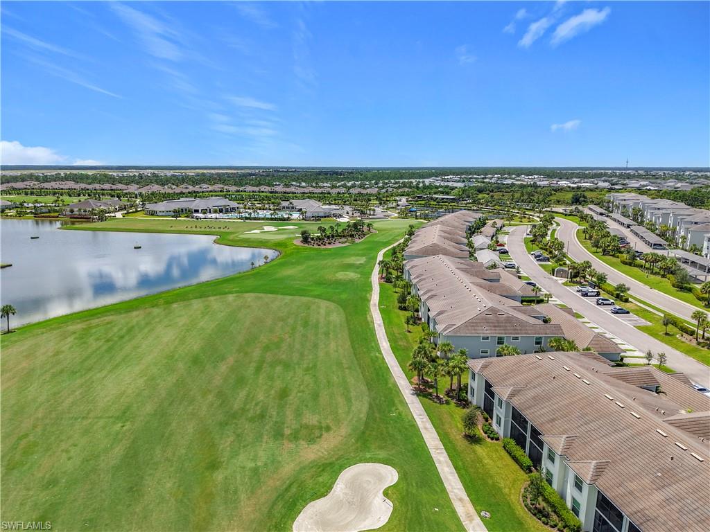 Aerial view of residential area featuring a nearby body of water and a golf club