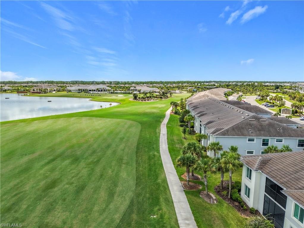 Aerial perspective of suburban area with a nearby body of water and a golf club