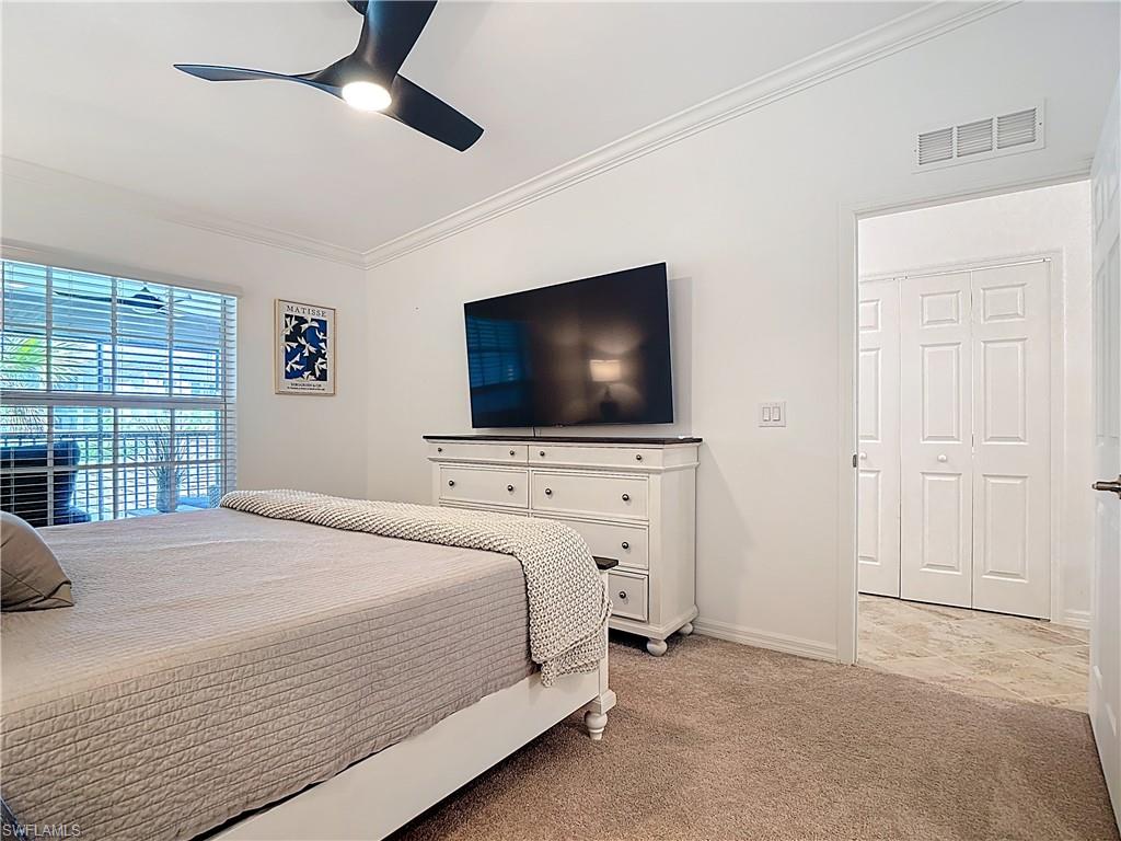 Bedroom featuring crown molding, light colored carpet, and ceiling fan