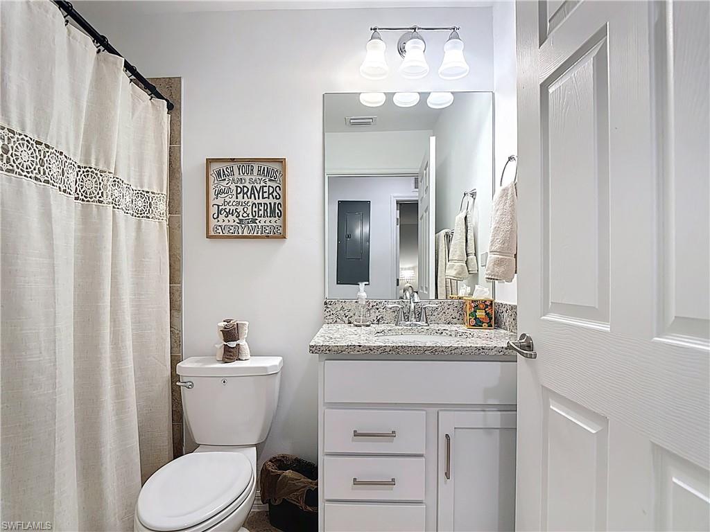 Full bathroom featuring vanity, a shower with curtain, and electric panel