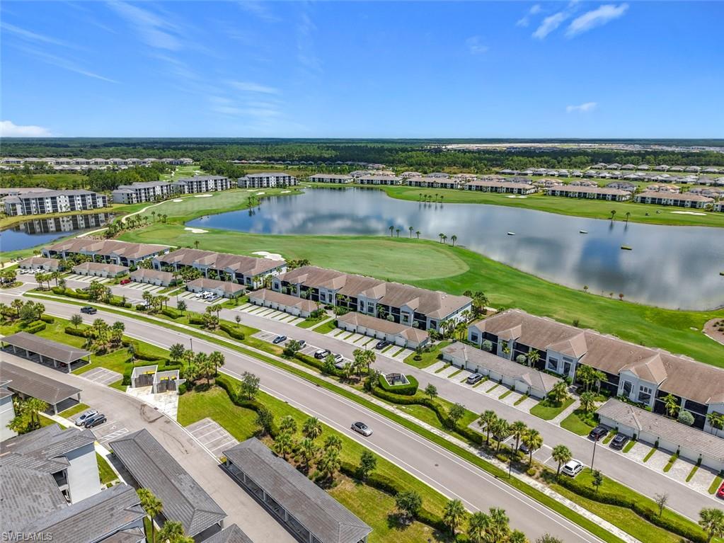 Aerial perspective of suburban area featuring a nearby body of water and a golf course