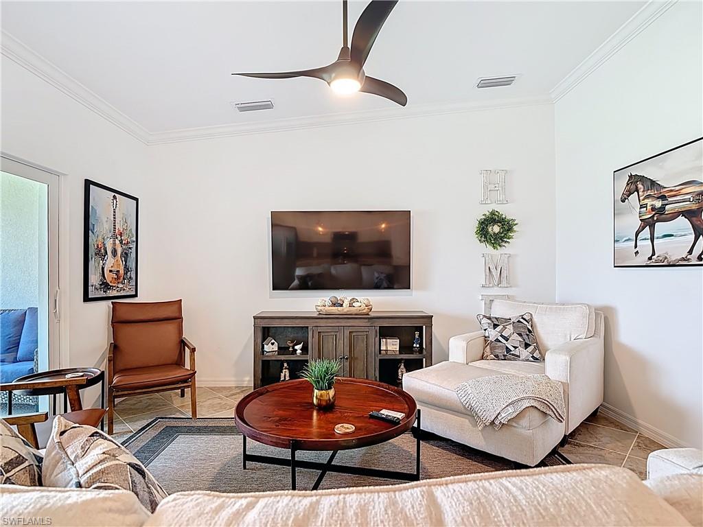 Tiled living room with crown molding and ceiling fan