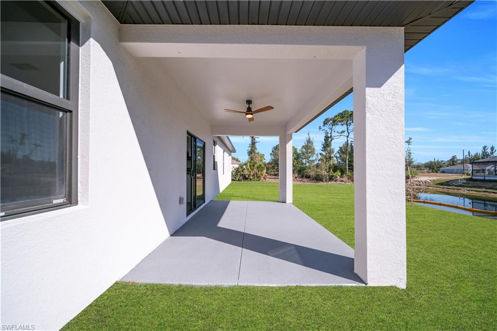Expansive covered patio with a ceiling fan, offering direct access via sliding glass doors