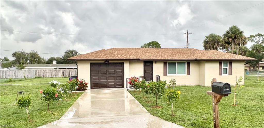 Single-story residence featuring a brown shingle roof, attached garage with a panel door, and stucco exterior