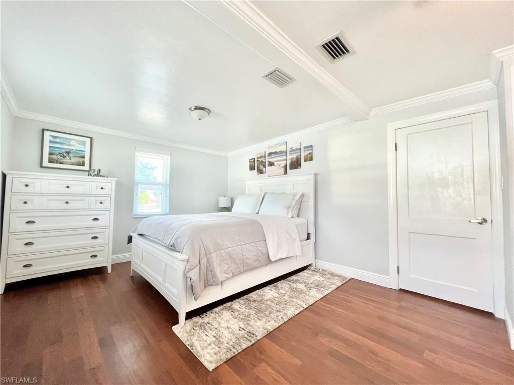 Hardwood-style flooring throughout, white trim, recessed lighting, and a white paneled door