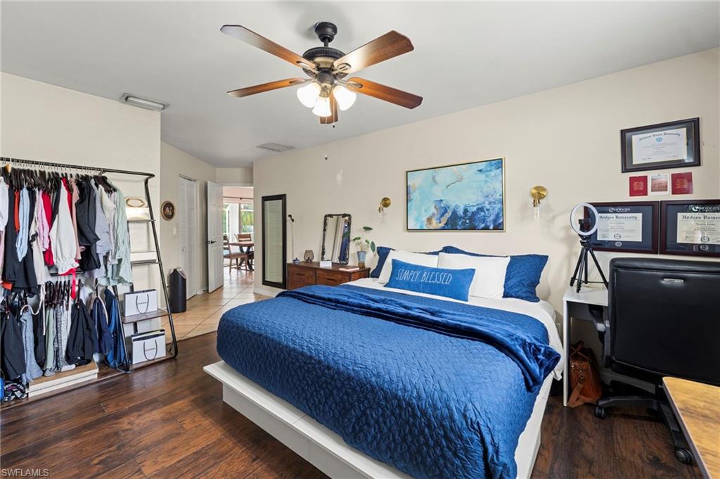 Wood-finish flooring, ceiling fan with integrated lighting, recessed lighting, and a white interior door