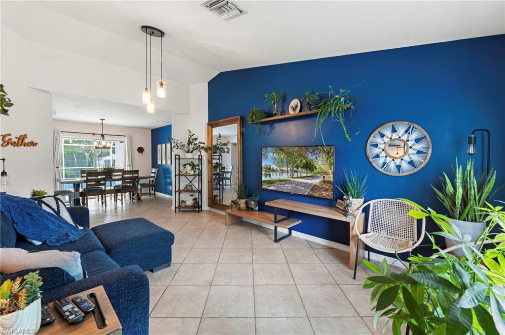 Expansive living area with tile flooring and a vibrant accent wall