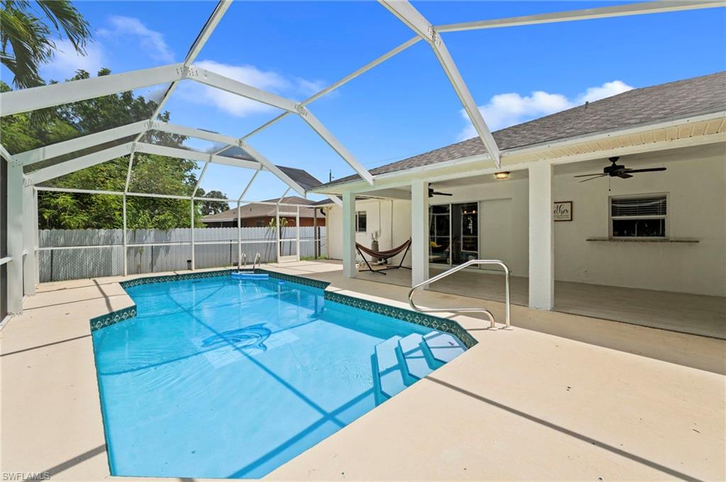 Screened-in pool with a concrete pool deck and integrated steps