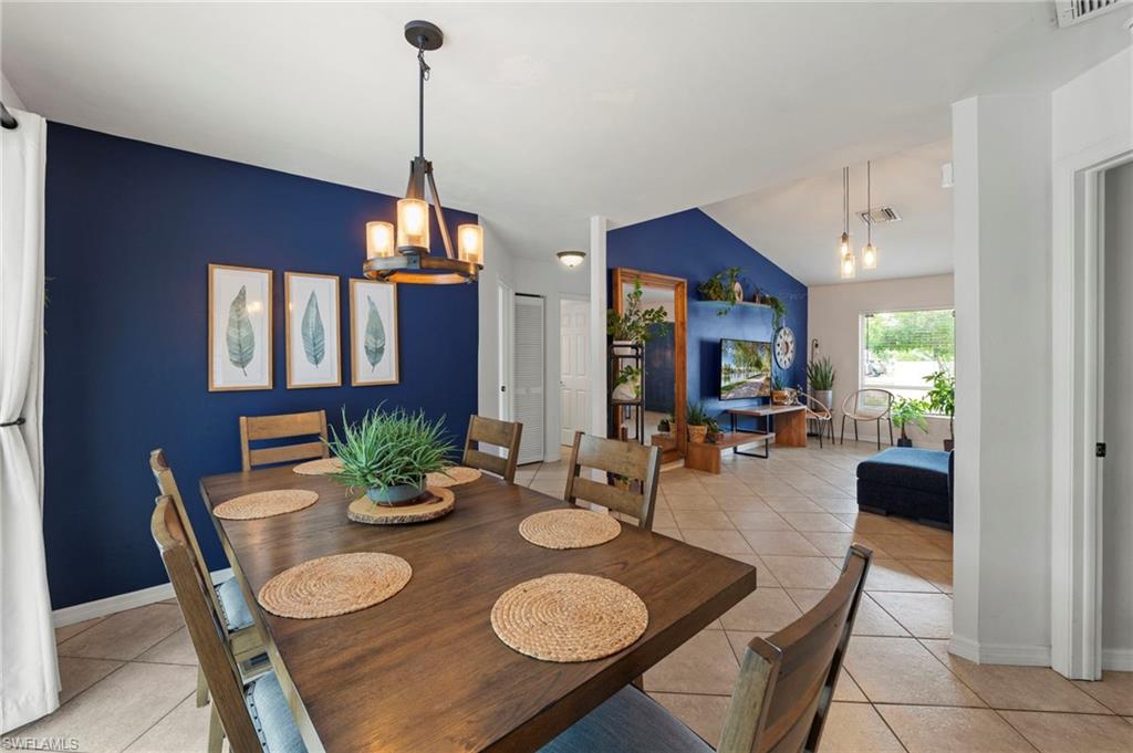 Vaulted ceilings, a prominent accent wall, and tiled flooring create an inviting atmosphere