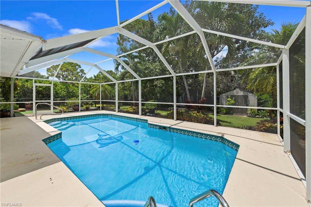 Screened lanai with sparkling saltwater pool featuring a geometric design and integrated spa jets