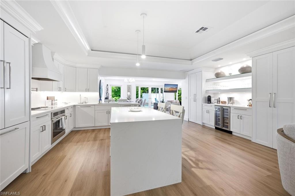 Features tray ceiling, white shaker cabinetry, convection oven, wide plank flooring