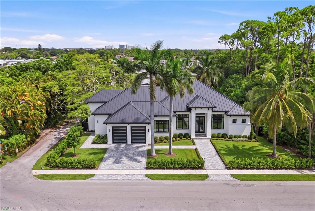 Contemporary residence featuring a dark metal roof and white exterior