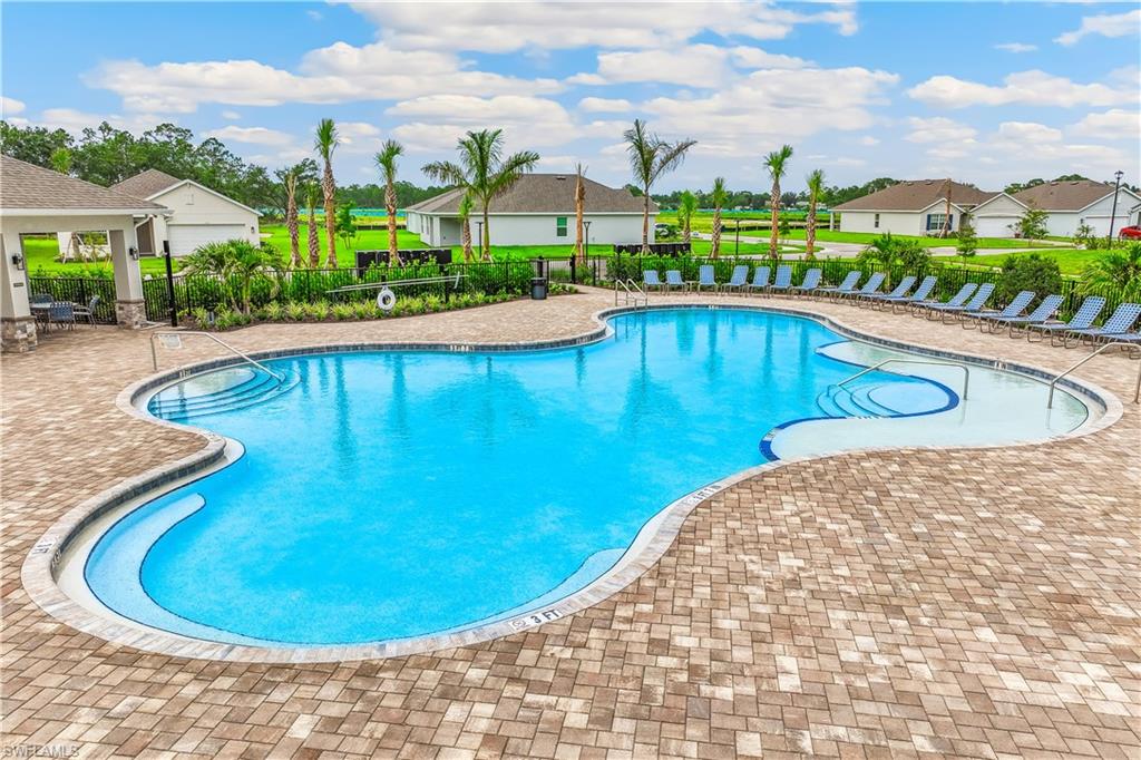 Community swimming pool featuring a freeform design, integrated steps, and a surrounding paver deck