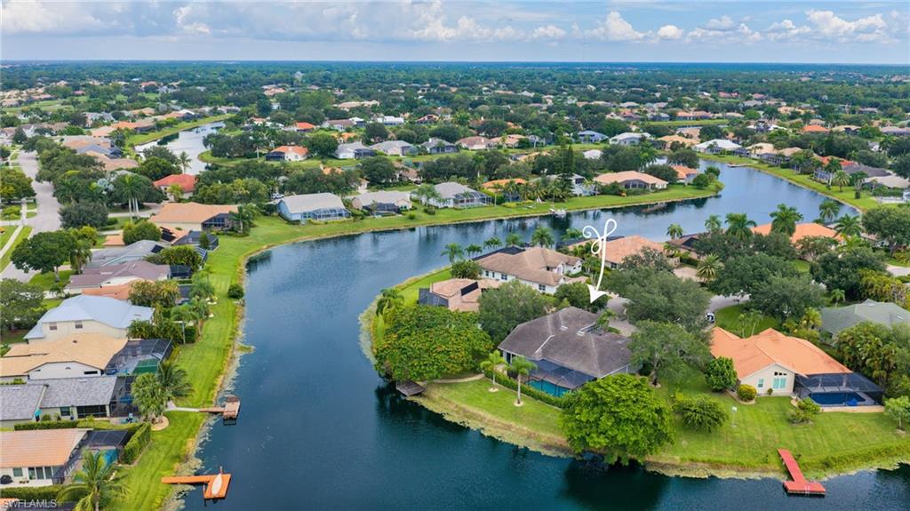 Waterfront property with private pool, mature landscaping, and an expansive paved patio