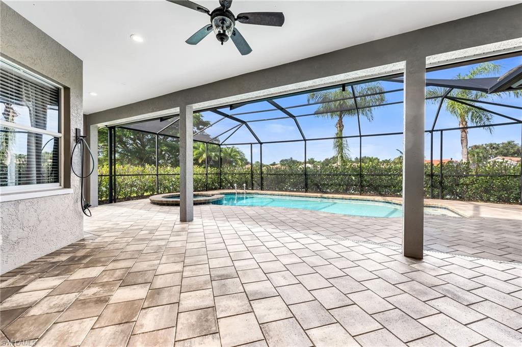 Expansive screened patio featuring a ceiling fan, recessed lighting, paver flooring, a built-in pool, and a circular spa