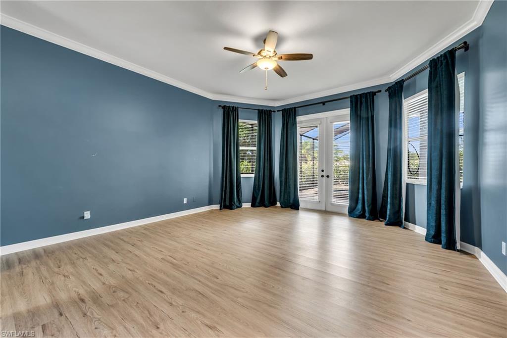 Wood-finish flooring with crown molding and recessed lighting