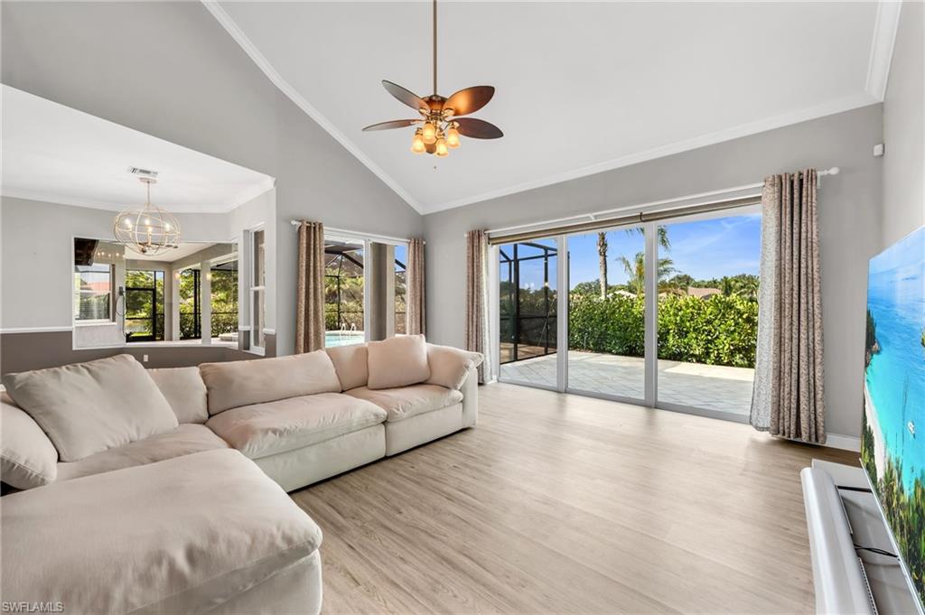 Vaulted ceiling with an attached ceiling fan, wood-finish flooring, and sliding glass doors