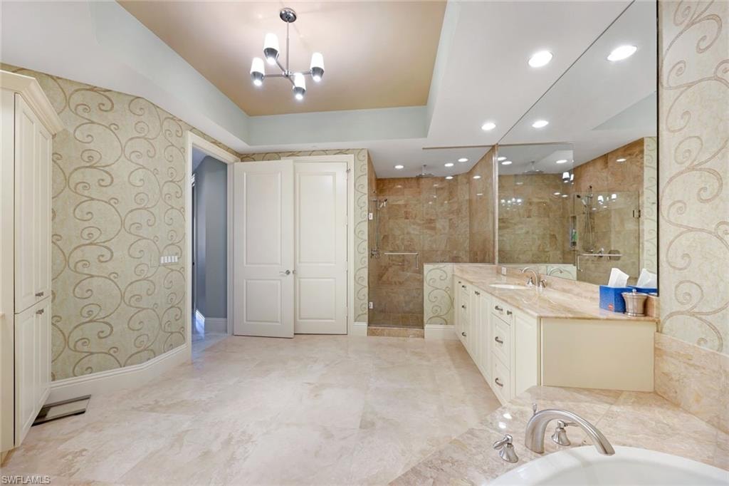 Tiled flooring throughout, dual vanity with undermount sinks, built-in cabinetry, glass-enclosed shower, and a built-in tub