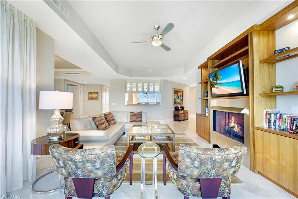 Integrated entertainment center with built-in shelving, a mounted television, and a fireplace