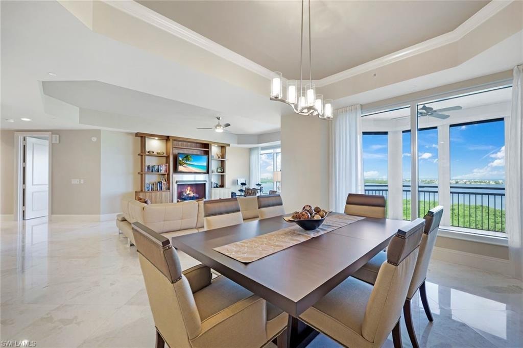 Spacious open-concept living area featuring a built-in entertainment center with a fireplace, large sliding glass doors, and polished tile flooring