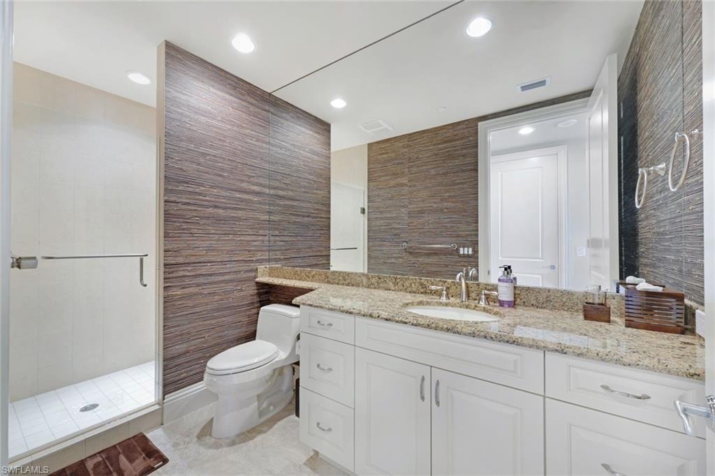 Walk-in shower with clear glass enclosure and chrome hardware