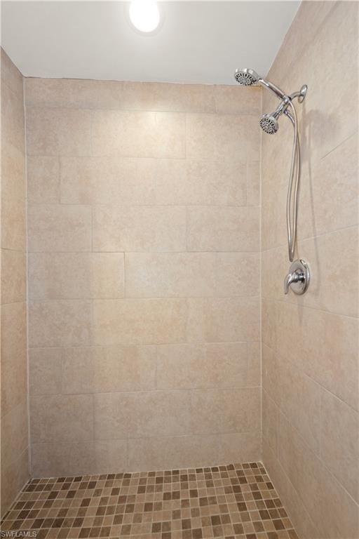 Tiled shower enclosure featuring a dual shower head system and recessed ceiling lighting