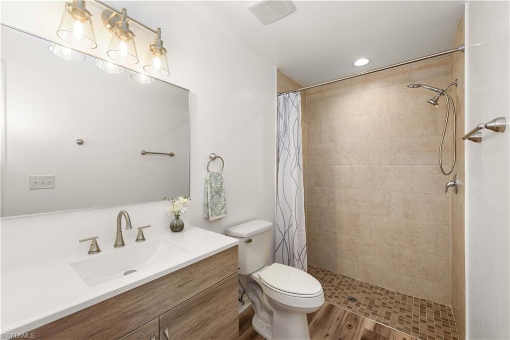 Vanity with integrated sink, wood-finish cabinetry, and brushed nickel faucet