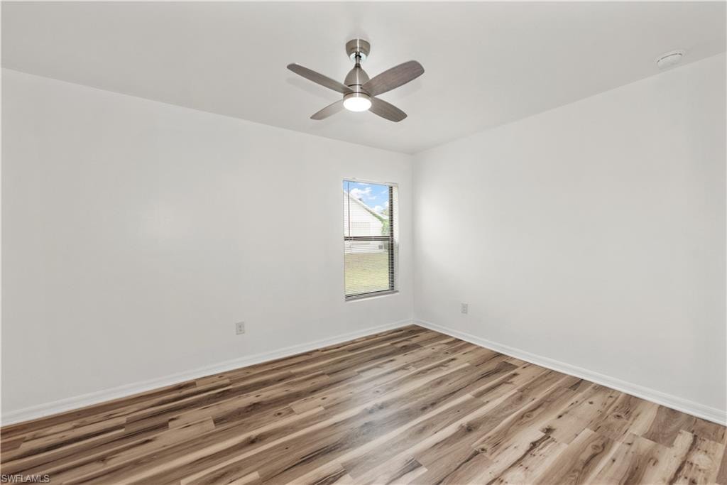 Neutral white walls with wood-finish flooring and a single window