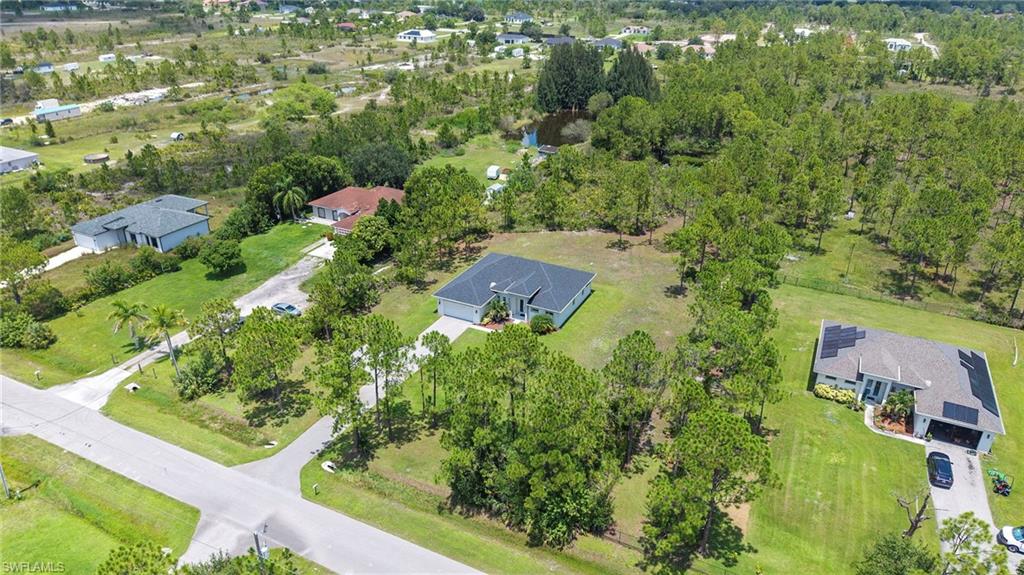 Sprawling residential lot featuring mature tree-lined landscape, manicured lawn, and multiple structures set across expansive acreage