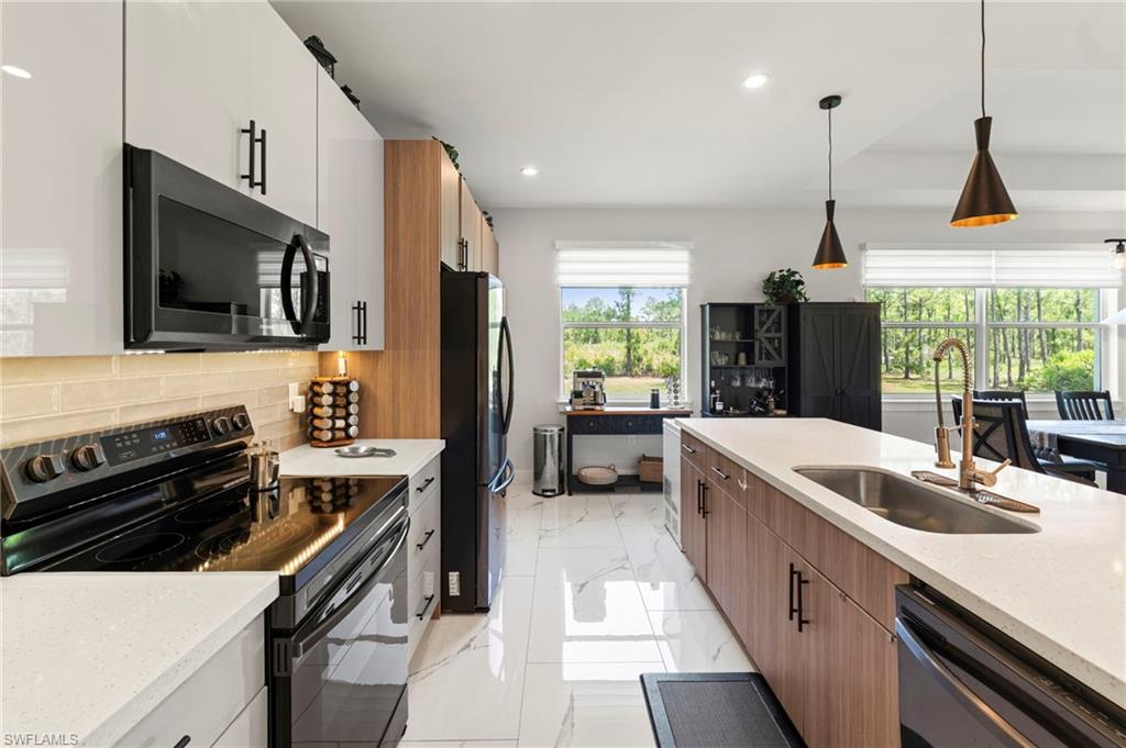 Modern kitchen featuring white glossy upper cabinetry, wood-finish lower cabinetry, white solid surface countertops, and white polished tile flooring