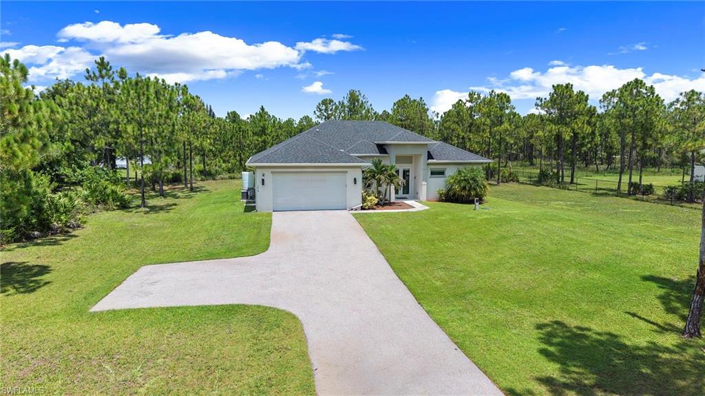 Single-story residence featuring a white stucco exterior, dark shingled roof, and an attached two-car garage