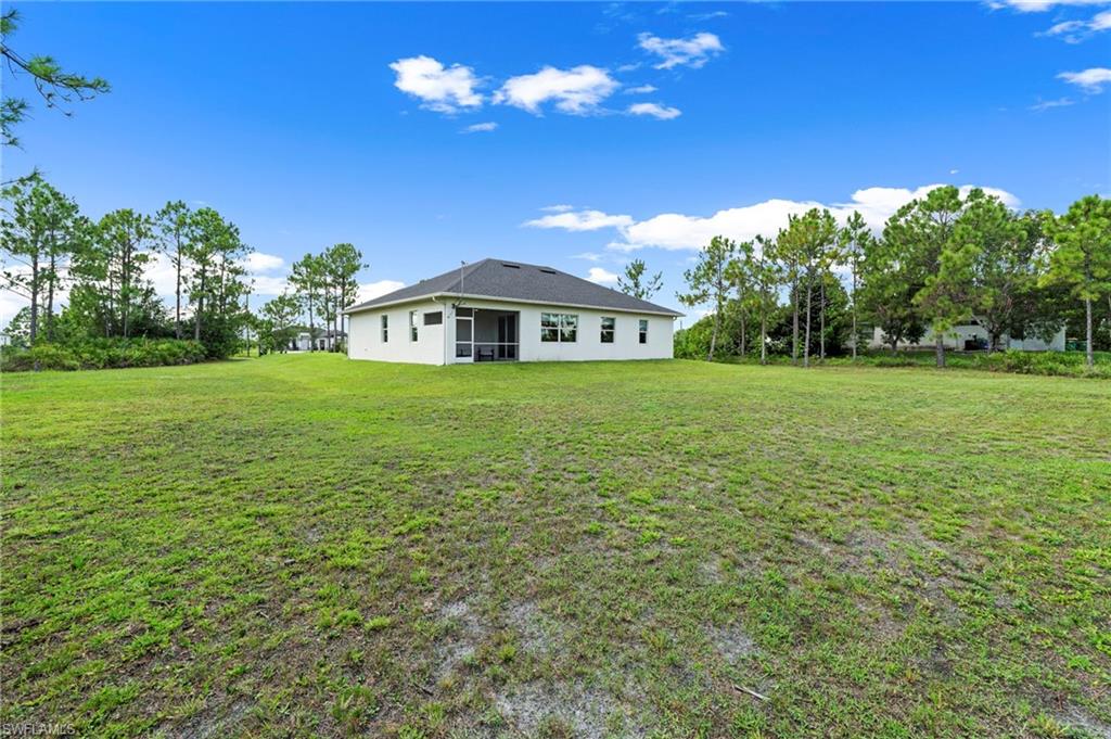 Expansive grounds featuring a manicured lawn with mature trees throughout the property