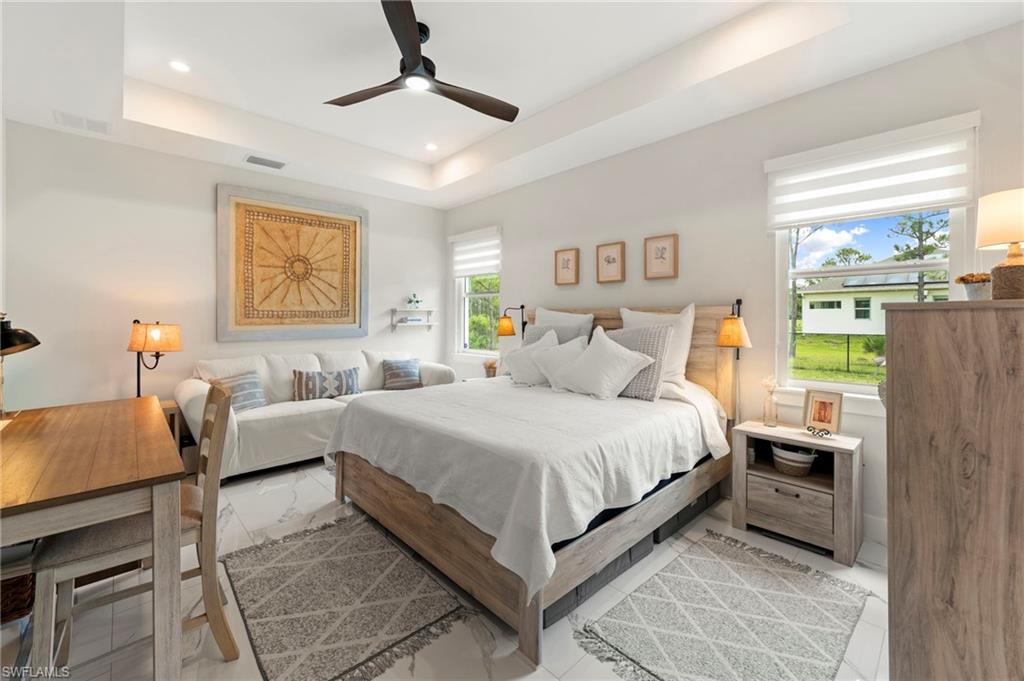 Recessed ceiling lighting, ceiling fan, tray ceiling, and white window treatments