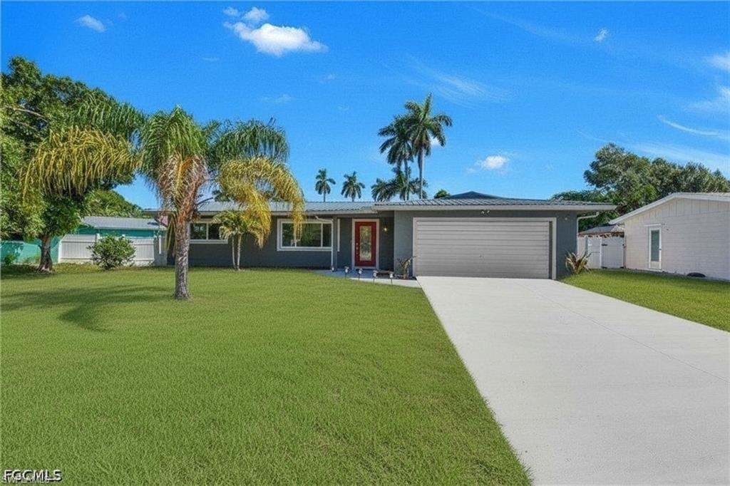 Single-story residence featuring a gray exterior, a red entry door, a two-car garage, and a concrete driveway