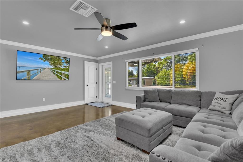 Recessed lighting, ceiling fan, wood-finish flooring, white trim, and a large window