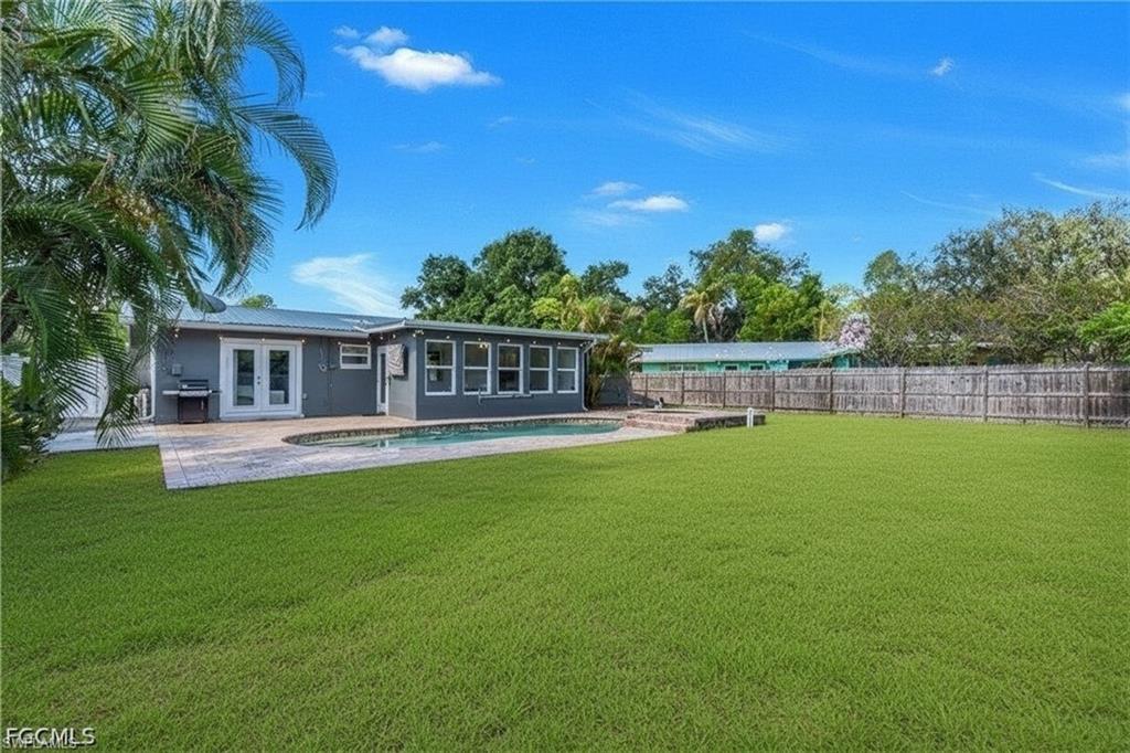 Expansive backyard featuring a fenced perimeter, swimming pool, and paver patio