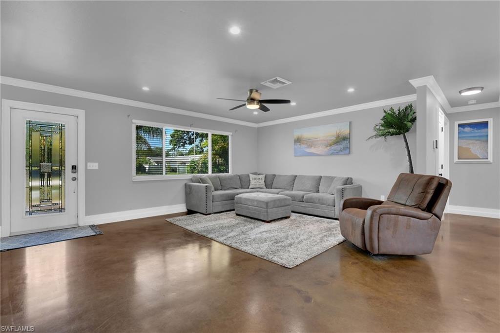 Spacious living area featuring polished concrete flooring, recessed lighting, and a ceiling fan