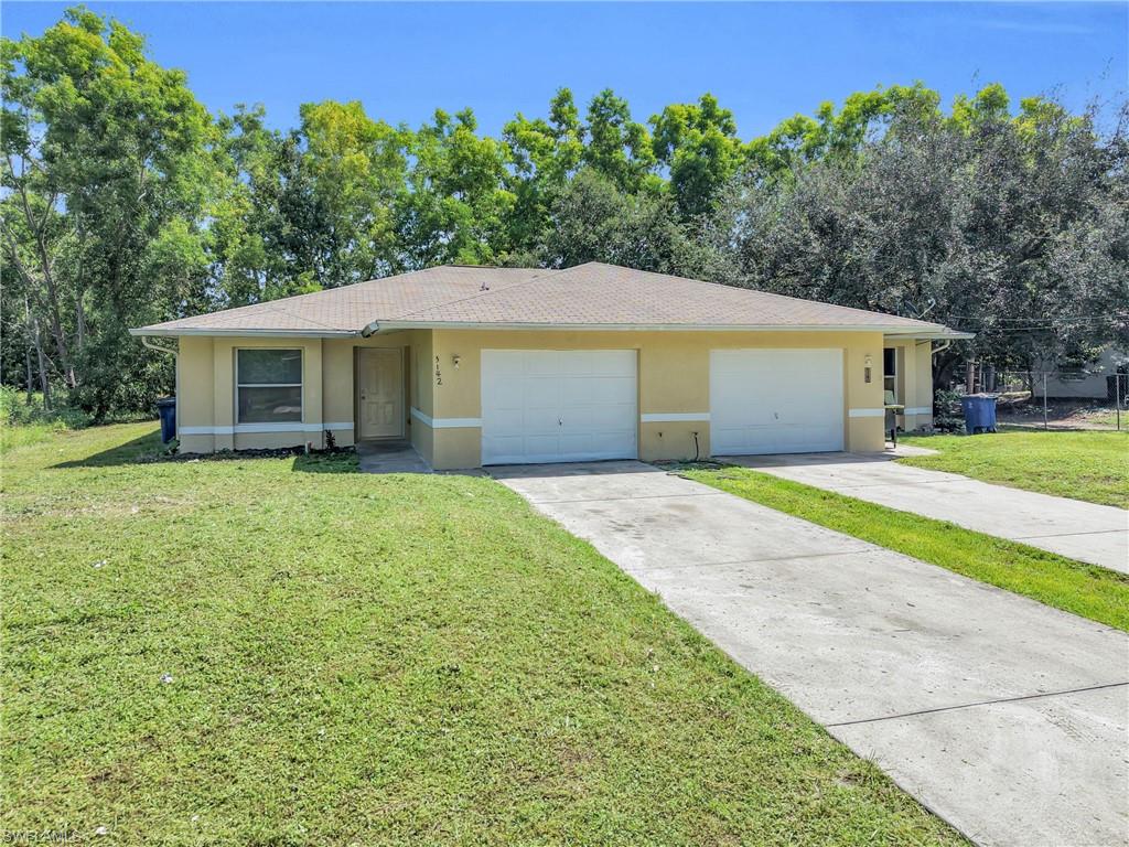 Exterior with light-toned stucco finish, dual single-car garages, a single entry door, and a concrete driveway