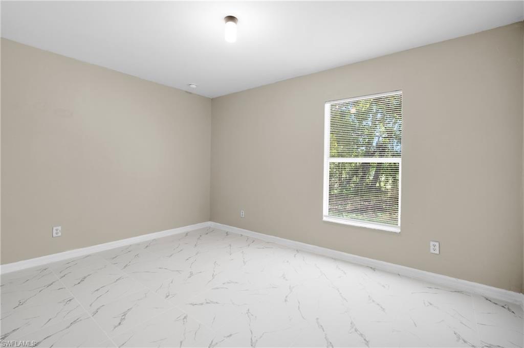 Light-filled interior featuring neutral wall tones and large format tile flooring