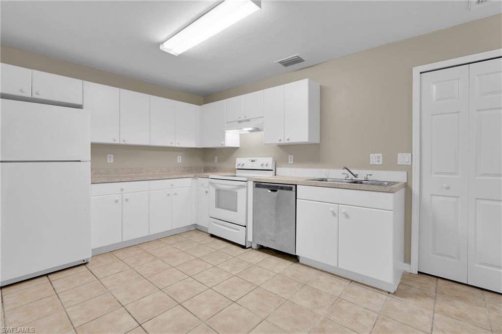 Kitchen featuring white cabinetry, tile flooring, and integrated appliances