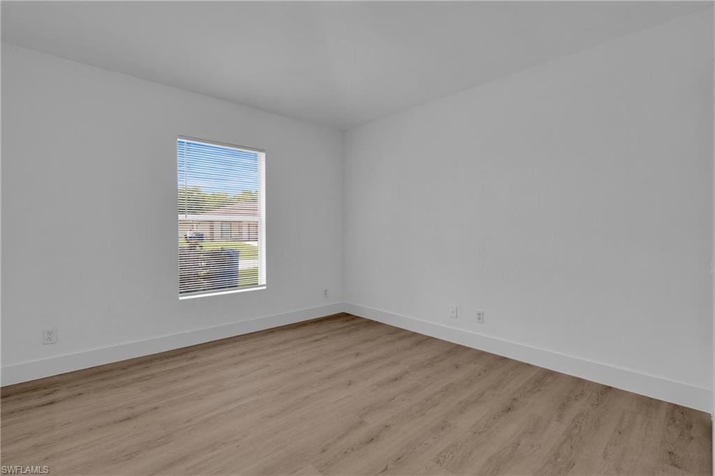 Wood-finish flooring with white baseboards and neutral wall tones