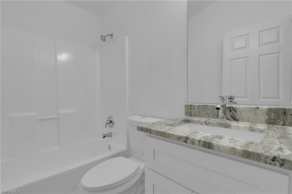 White vanity with an integrated rectangular sink, chrome fixtures, and a speckled countertop