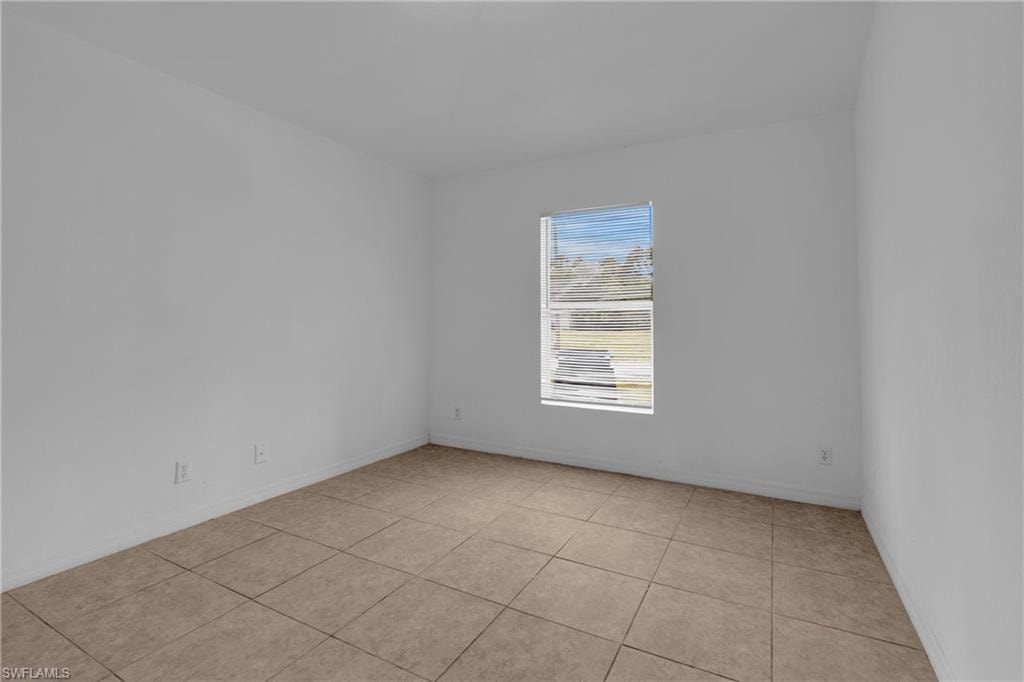 Neutral-toned ceramic tile flooring, a window with horizontal blinds, and light-colored walls
