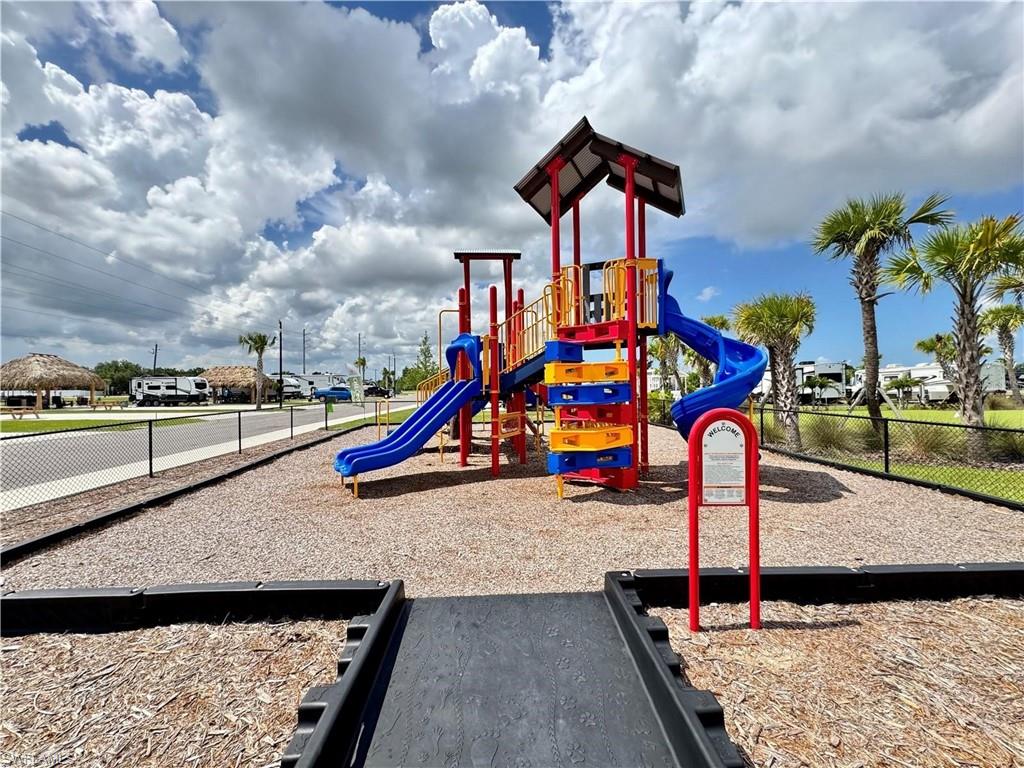 Playground featuring multiple slides, a climbing structure, and wood chip ground cover