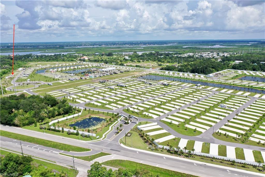 Expansive property featuring numerous individual sites, paved access roads, structured landscaping, and a central water feature