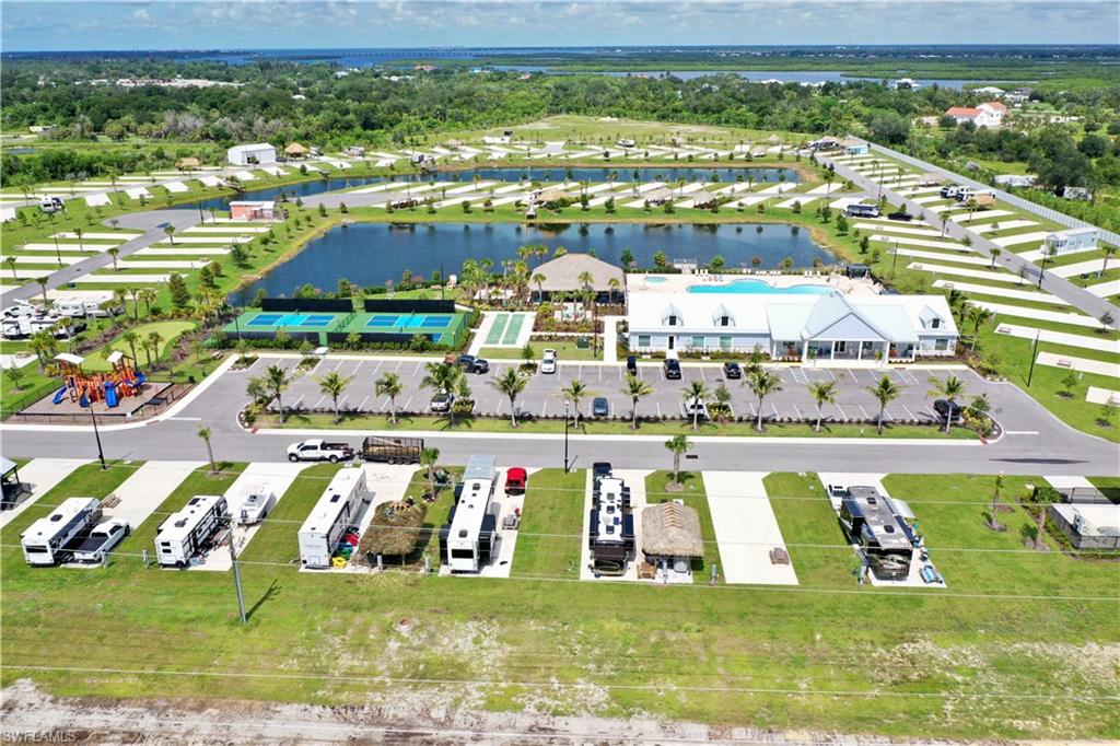 Outdoor recreational complex featuring a swimming pool, tennis courts, and a playground