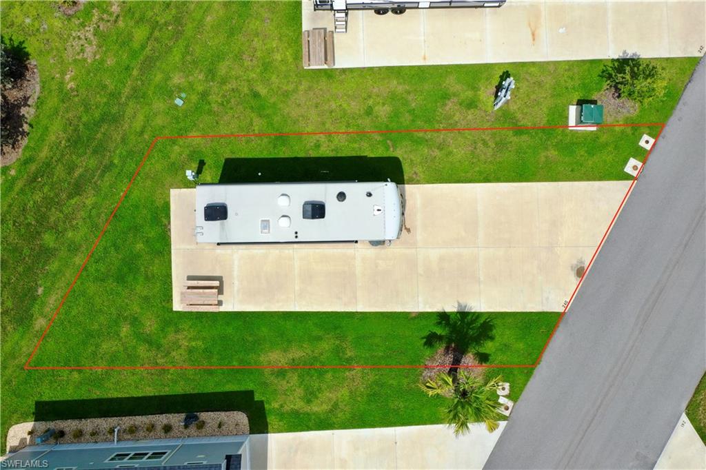 Paved lot with concrete pad, surrounded by green lawn