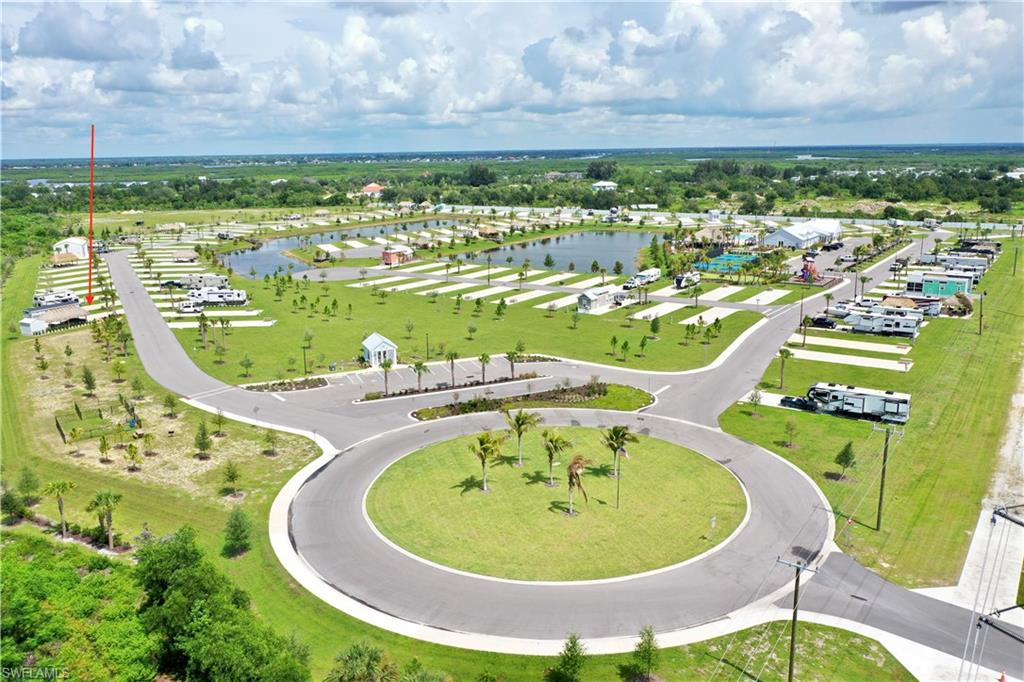 Expansive property with multiple paved roads, a central roundabout, and a large central pond feature